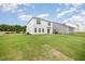 View of the home's exterior, a well-maintained lawn, and lush trees bordering the property in the backyard at 58 W Emily Gardens Dr, Selma, NC 27576