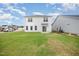 Spacious backyard features a lush lawn and the home's exterior, complete with a sliding glass door entry at 58 W Emily Gardens Dr, Selma, NC 27576