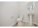 Small bathroom with a toilet, a small sink, wood look floors, and neutral paint at 58 W Emily Gardens Dr, Selma, NC 27576
