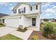 Charming two-story home featuring a two-car garage, front porch, well-maintained lawn, and classic black-and-white color scheme at 58 W Emily Gardens Dr, Selma, NC 27576