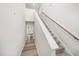 Bright hallway with carpeted stairs, wooden handrail, and hard surface flooring leading to the front door at 58 W Emily Gardens Dr, Selma, NC 27576