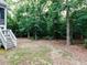 A tree-filled backyard with mature foliage and stairs leading to the deck at 604 Doddington Dr, Rolesville, NC 27571