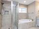 Modern bathroom with separate shower and soaking tub with large window, offering a spa-like experience at 604 Doddington Dr, Rolesville, NC 27571