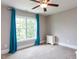 Cozy bedroom with bright window, blue curtains, carpeted floors, and ceiling fan at 604 Doddington Dr, Rolesville, NC 27571