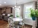 Bright breakfast nook features a white table, hardwood floors, large windows and stylish modern lighting at 604 Doddington Dr, Rolesville, NC 27571