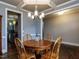 Dining room with hardwood floors and a wooden table and chairs under a modern chandelier at 604 Doddington Dr, Rolesville, NC 27571