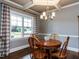 Dining room has a wooden table, 4 wooden chairs, a chandelier, and a large window with checked curtains at 604 Doddington Dr, Rolesville, NC 27571