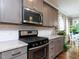 Updated kitchen features stainless steel oven, microwave, white subway tile backsplash, and gray cabinets at 604 Doddington Dr, Rolesville, NC 27571