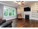 Spacious living room with hardwood floors, built-in bookshelves, a modern fireplace, and large window at 604 Doddington Dr, Rolesville, NC 27571
