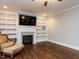 Living room boasts built-in shelves, a fireplace, crown molding, hardwood floors, and plenty of space at 604 Doddington Dr, Rolesville, NC 27571