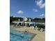 Community pool with comfortable seating and umbrellas by the pool house on a sunny day at 604 Doddington Dr, Rolesville, NC 27571