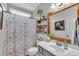 Charming bathroom with a floral shower curtain, floating shelves, wood-trimmed mirror, and gray vanity at 71 Smithsanders Ct, Smithfield, NC 27577