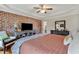 Bedroom with exposed brick accent wall, hardwood floors, and tray ceiling at 71 Smithsanders Ct, Smithfield, NC 27577