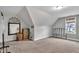Spacious bonus room with neutral carpet, dormer window, sloped ceilings and accent mirror at 71 Smithsanders Ct, Smithfield, NC 27577