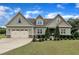 Charming two-story home featuring a manicured lawn, an attached two-car garage, and lovely landscaping at 71 Smithsanders Ct, Smithfield, NC 27577