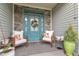Cozy front porch with chairs and a decorative wreath on the teal front door at 71 Smithsanders Ct, Smithfield, NC 27577