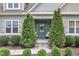 Inviting front porch with twin evergreens framing an entryway with a teal front door at 71 Smithsanders Ct, Smithfield, NC 27577