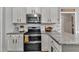 Kitchen features white cabinets, granite countertops, stainless steel appliances, and tile backsplash at 71 Smithsanders Ct, Smithfield, NC 27577