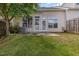 A view of the cozy backyard featuring green grass, a small concrete patio, and partial fence at 8004 Thrush Ridge Ln, Raleigh, NC 27615