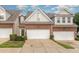 Inviting brick townhome featuring an attached garage, manicured lawn, and classic architectural details at 8004 Thrush Ridge Ln, Raleigh, NC 27615