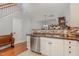 Well-lit kitchen featuring stainless steel dishwasher and dark countertop, offering easy access to the stairs at 8004 Thrush Ridge Ln, Raleigh, NC 27615
