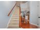 Inviting staircase with carpeted steps and a wooden banister, leading to an open floor plan and kitchen at 8004 Thrush Ridge Ln, Raleigh, NC 27615