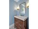 The powder room is painted blue and features a modern vanity and mirror at 84307 Winslow, Chapel Hill, NC 27517