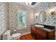 Charming powder room with floral wallpaper, granite counters, and hardwood flooring at 84307 Winslow, Chapel Hill, NC 27517