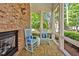 Relaxing screened porch with brick fireplace and rocking chairs overlooking the backyard's serene, wooded view at 84307 Winslow, Chapel Hill, NC 27517