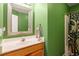 Green bathroom featuring a vanity with an oval sink and shower with decorative curtain at 9504 Anson Grove Lane Ln, Raleigh, NC 27615
