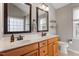 Bathroom featuring a double vanity, wood cabinets, framed mirrors, and a separate toilet room at 9504 Anson Grove Lane Ln, Raleigh, NC 27615