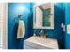 Stylish bathroom with a modern sink, gold faucet, bold blue walls, and colorful wallpaper at 9504 Anson Grove Lane Ln, Raleigh, NC 27615