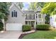 Charming gray two-story home boasts a manicured lawn, attached garage, and inviting front porch at 9504 Anson Grove Lane Ln, Raleigh, NC 27615