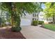 View of the home's garage and driveway, enhanced by lush landscaping and mature trees at 9504 Anson Grove Lane Ln, Raleigh, NC 27615