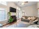 Comfortable living room featuring a fireplace, ceiling fan, and large windows allowing ample natural light at 9504 Anson Grove Lane Ln, Raleigh, NC 27615