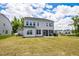 Expansive backyard with green grass, view of house, screened in porch and partial trees at 1051 Jura Ridge Dr, Fuquay Varina, NC 27526