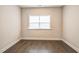 An empty bedroom with hard wood floors and a window with bright natural light at 1051 Jura Ridge Dr, Fuquay Varina, NC 27526