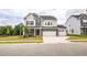 Charming two-story home with stone accents, a three-car garage, and a well-manicured lawn at 1051 Jura Ridge Dr, Fuquay Varina, NC 27526