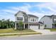 Attractive two-story house featuring stone accents, three-car garage and landscaped front yard at 1051 Jura Ridge Dr, Fuquay Varina, NC 27526