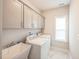 Well-lit laundry room with modern washer and dryer, cabinets and sink at 1051 Jura Ridge Dr, Fuquay Varina, NC 27526