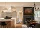 Modern kitchen and dining area with a marble backsplash, stainless steel appliances, and a cozy fireplace at 1113 Mordecai Dr, Raleigh, NC 27604