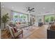 Bright living room featuring a ceiling fan, hardwood floors, and large windows providing natural light at 1165 Tembrook Dr, Mebane, NC 27302