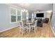 Bright dining area features modern chandelier, wood flooring, and comfortable seating with views to living room at 1208 Brown Velvet Ln, Apex, NC 27523