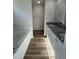 Bathroom showcasing a bathtub, wood-look flooring, granite counters, and dual sinks at 128 Oakfield Trace Dr, Four Oaks, NC 27524