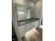 Bathroom featuring granite counters, dual sinks, and wood-look flooring at 128 Oakfield Trace Dr, Four Oaks, NC 27524