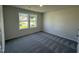 Well-lit bedroom featuring plush carpeting and windows at 128 Oakfield Trace Dr, Four Oaks, NC 27524