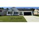 Charming one-story home with a well-manicured lawn, black garage door, and complementary landscaping at 128 Oakfield Trace Dr, Four Oaks, NC 27524