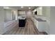A modern kitchen features white cabinets, granite countertops, stainless steel microwave, and wood floors at 128 Oakfield Trace Dr, Four Oaks, NC 27524