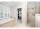 Light-filled bathroom with a soaking tub and a walk-in shower with glass enclosure at 1414 Park Dr, Raleigh, NC 27605