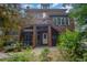 Red brick home with back porch, staircase and lush foliage at 1414 Park Dr, Raleigh, NC 27605